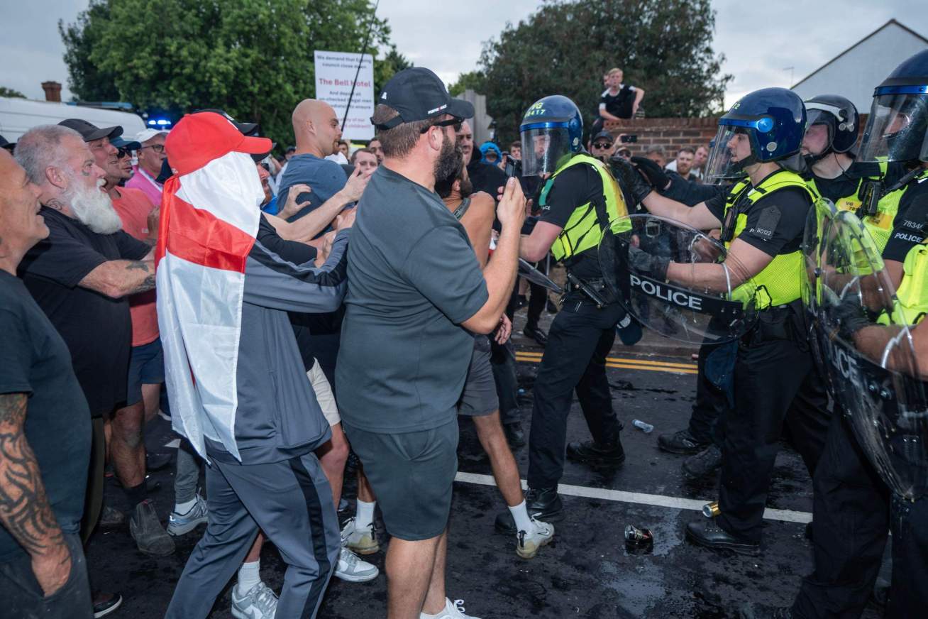 Far-right anti-immigration protestors scuffle with a cordon of riot police  outside The Bell Hotel in Epping, Essex, following an asylum seeker's accusation of sexual assault in July 2025. Photo: ZUMA Press Inc