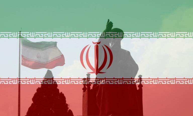 Tehran, Iran - June 10, 2018: A large Iranian flag waving in the wind behind a statue of Khomeini in Tehran, Iran