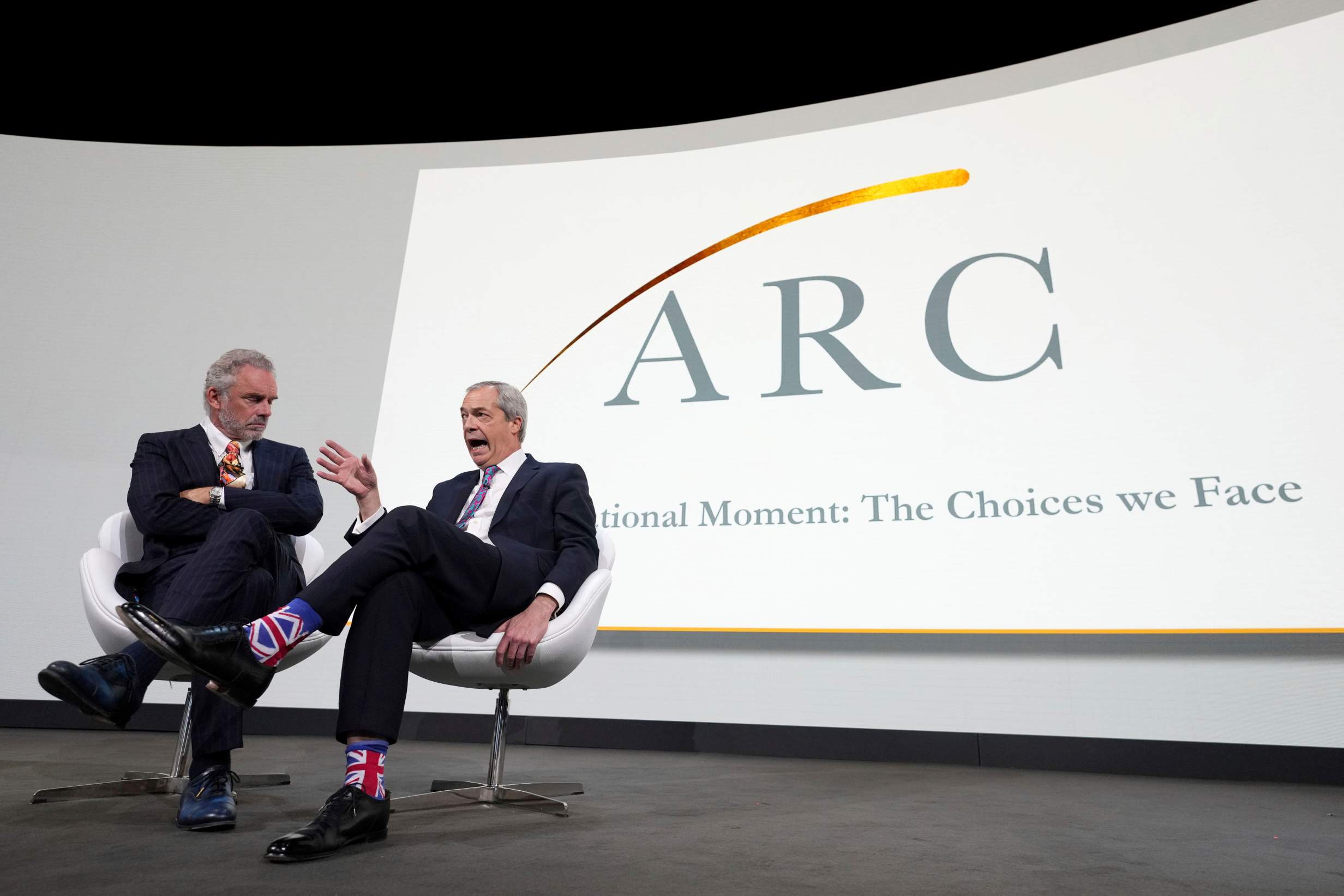 Nigel Farage, Leader of Reform UK, right, as he is interviewed on stage by Jordan Peterson, left, at the ARC (Alliance for Responsible Citizenship) conference in London, Tuesday, Feb. 18, 2025. (AP Photo/Kirsty Wigglesworth)